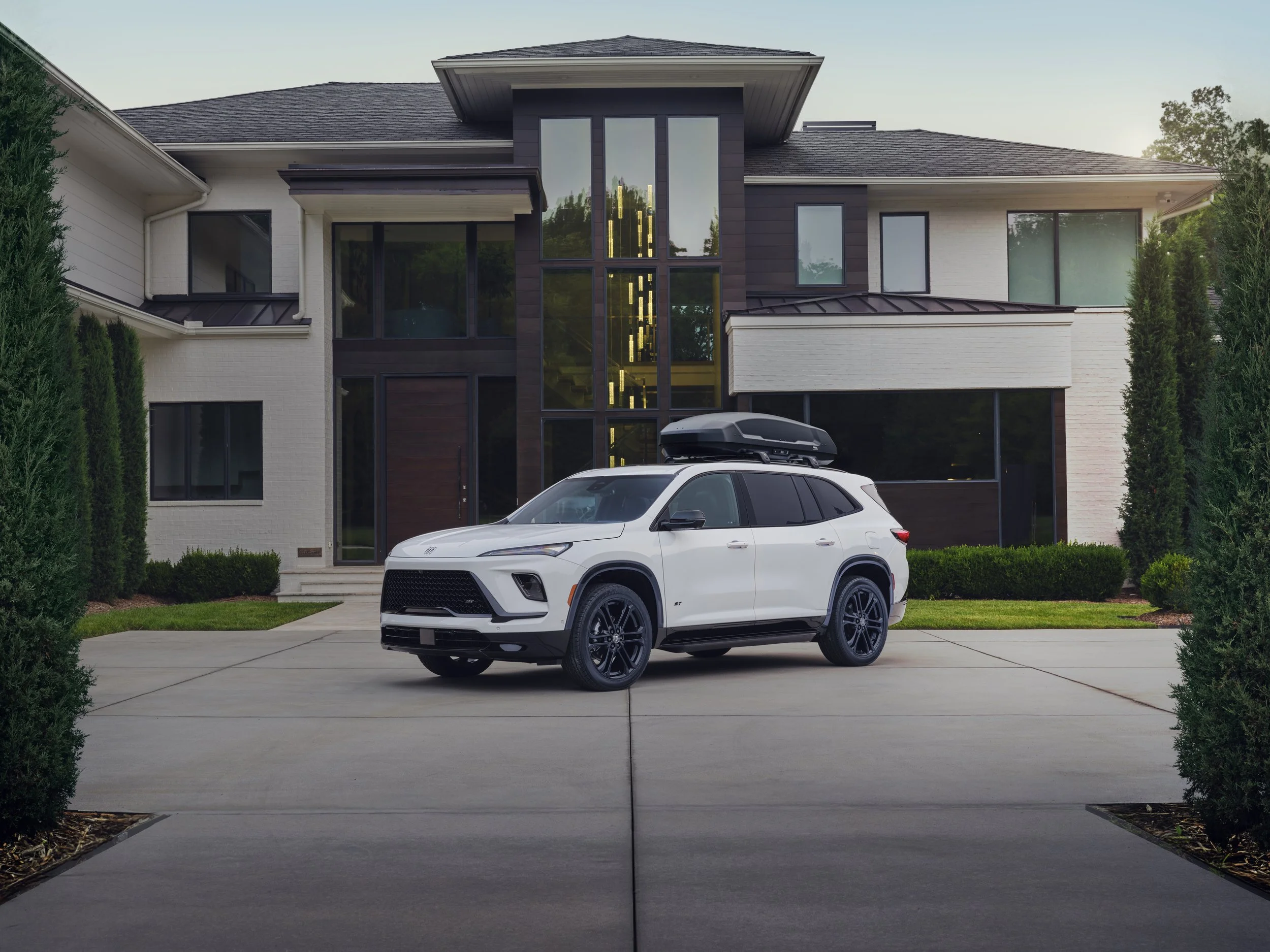 White 2025 Buick Enclave ST with black roof cargo box parked in driveway