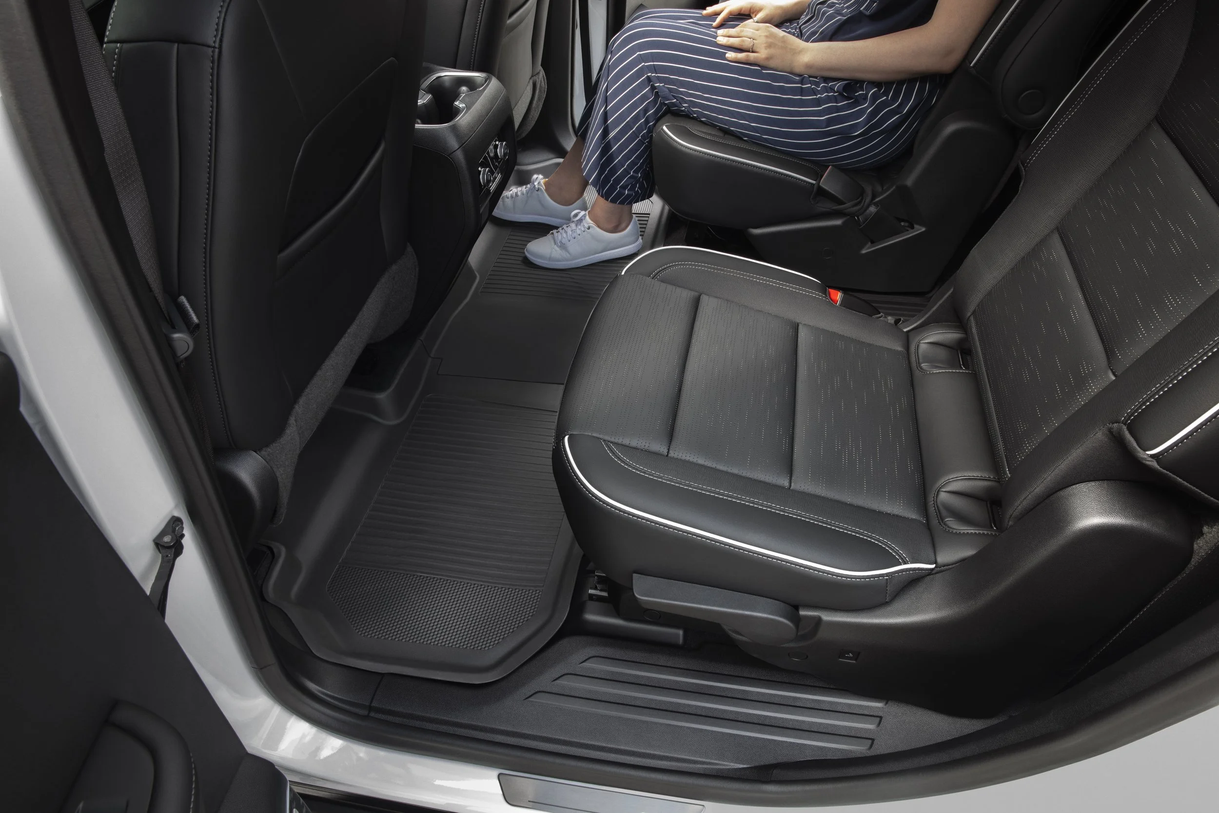 Buick Enclave second-row interior with black leather seats and open-door legroom