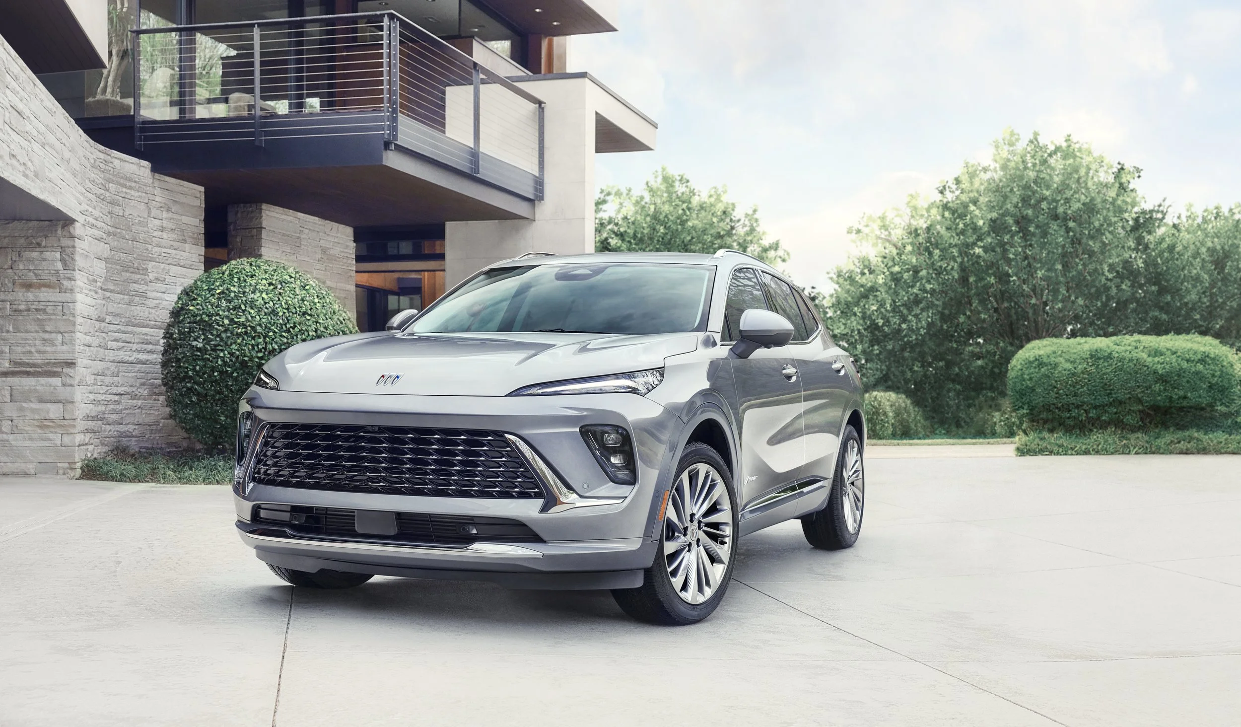 Silver Buick Envision Avenir parked in the driveway of a modern home